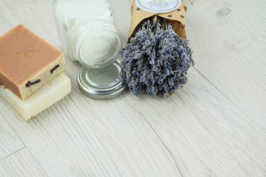 El yapımı kozmetik krem kavanozu, sabun ve hafif arka planda kurutulmuş lavanta çiçekleri. Biyolojik organik kozmetik. Bitki üssü.