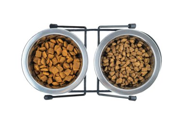 Beyaz arka planda izole edilmiş metal kaselerdeki kedi ve köpekler için kuru yiyecekler. Üst görünüm.