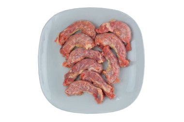Chicken necks in plate isolated on white background. Top view. 