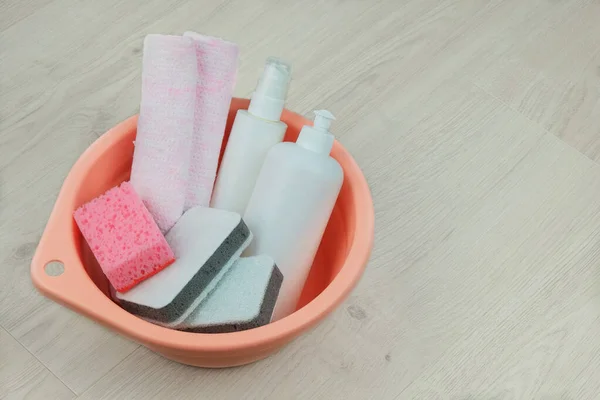 Cleaning Concept Detergent Bottles Washcloths Housekeeping Pink Basin Wooden Background — стоковое фото
