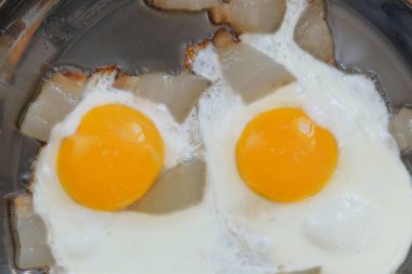 Yağda yumurta ve metal tavada domuz yağı. Ev yapımı kahvaltı. Üst görünüm.