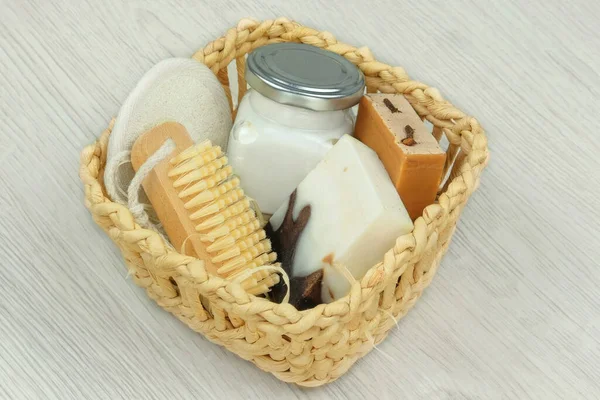 Nature cosmetics products. Handmade cosmetics products. Cosmetic products for body and accessories in a white straw basket on wood background.