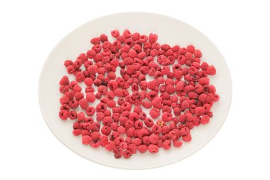 Beyaz arka planda izole edilmiş beyaz bir tabakta kurutulmuş ahududu. Yemek hareket halinde. Besleyici atıştırmalıklar. 