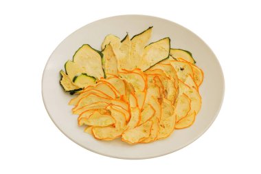 Beyaz arka planda izole edilmiş seramik tabakta kurutulmuş kabak. Bir sürü kuru kabak. Hayatta kalma yiyeceği. Yemek hazırlığı.