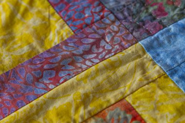 Batik kumaş kullanan el yapımı masa koşucusunun yakın plan ayrıntıları.