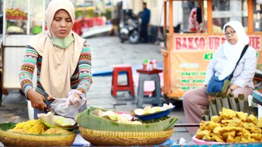 Jakarta, Endonezya - 9 Şubat 2024: Kota Tua 'daki Pecel tüccarları alıcılara hizmet veriyor. Pecel, fındık sosuna batırılmış hafif bembeyaz sebzelerden oluşan bir salatadır..
