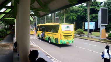 Depok, Endonezya - 25 Temmuz 2024: Endonezya Sarı Otobüs Üniversitesi veya tren istasyonunun önündeki Bikun.