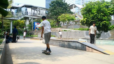 Jakarta, Endonezya - 6 Ekim 2024: Gençler Jalan Sudirman 'daki şehir parkında kaykay yapıyorlar.