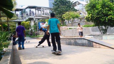 Jakarta, Endonezya - 6 Ekim 2024: Gençler Jalan Sudirman 'daki şehir parkında kaykay yapıyorlar.