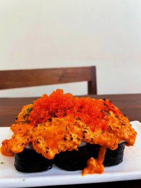 Baharatlı suşi rulosu. Üzerine kurutulmuş biber serpilmiş suşi rulosu..