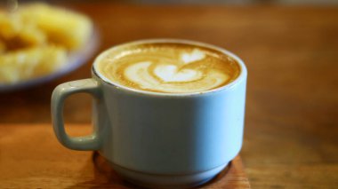 Bir fincan kapuçino ve kızarmış kasava..