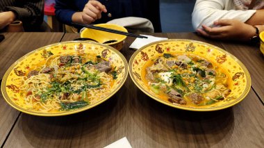 Çorbada hazır erişte, fasulye, taze sebze ve et var..