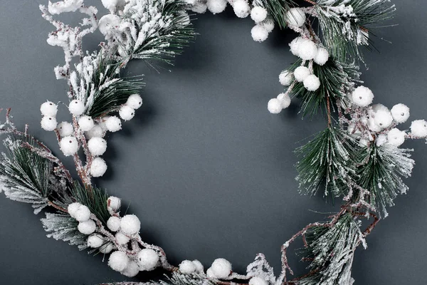 wreath of Christmas tree snow branches on a gray background. copy space flat lay. idea for postcards or tex