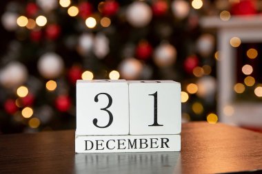 31 Aralık tarihli takvim mumların ve Noel dekorunun arka planında. Mutlu yıllar ve noeller.