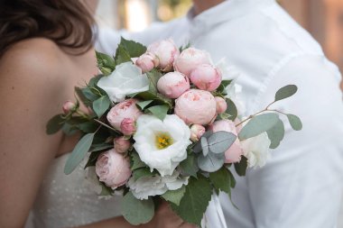 wedding delicate bouquet of flowers in the hands of the bride and groom on a holiday. concept idea for event agencie