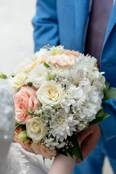 delicate wedding bouquet in the hands of the bride and groom. concept for event agencie