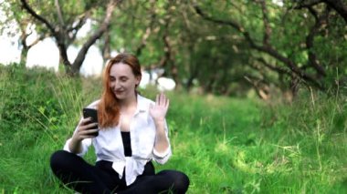 Bahçedeki kız video aracılığıyla iletişim kuruyor. Serbest çalışan biri. Gülümse.
