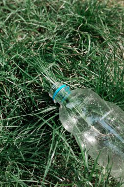 Ekoloji konsepti. Plastik şişeler çimenlere atılır.