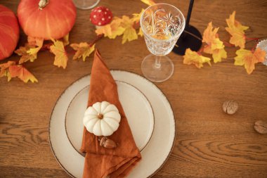 Yemek masasının sonbahar ayarı. Kırmızı ve sarı yapraklar ve balkabakları. Güzel masa dekorasyonu.