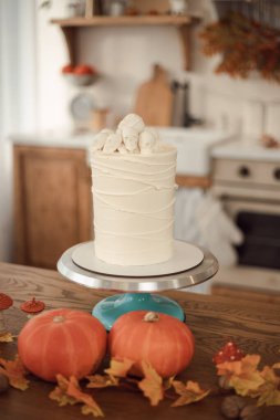 Cadılar Bayramı pastası fikri. Örümcek ağları ve kafatasları olan pasta. Mutfak sonbahar için dekore edilmiştir.