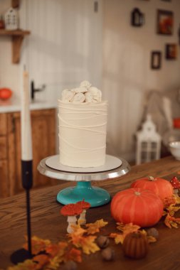 Cadılar Bayramı pastası fikri. Örümcek ağları ve kafatasları olan pasta. Mutfak sonbahar için dekore edilmiştir.