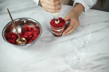 Process of creating red velvet trifle. Confectioner at work
