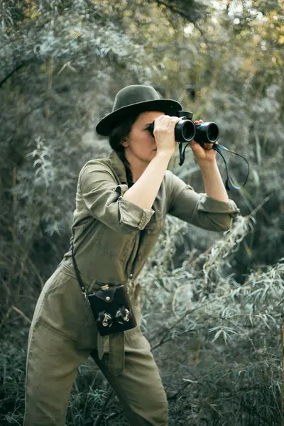 stock image Female traveler with binoculars in her hands is looking at animals in the thickets. Safari theme