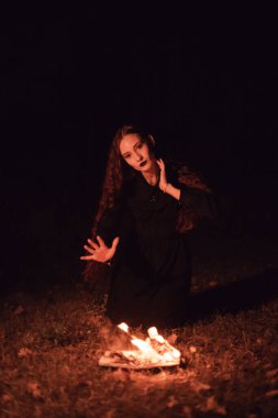 Cadı yanan bir kitabın üzerine büyü yapıyor, mistisizm, Cadılar Bayramı, gotik kadın.