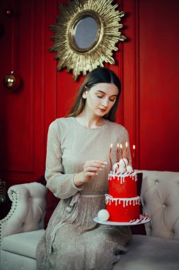 Kutlama kırmızı bir pasta ve mumlarla özel bir durum için dekore edilmiş rahat bir odada.