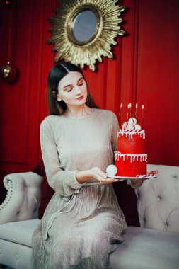 Kutlama kırmızı bir pasta ve mumlarla özel bir durum için dekore edilmiş rahat bir odada.