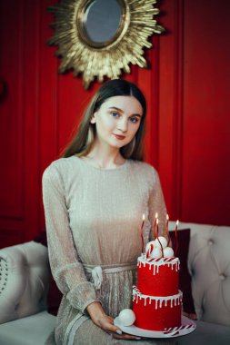 Kutlama kırmızı bir pasta ve mumlarla özel bir durum için dekore edilmiş rahat bir odada.