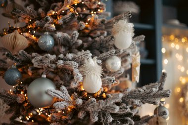 Karla kaplı Noel ağacı ve Noel ağacı süslemeleri. Noel ve yeni yıl tatilleri. Bokeh, arka plan bulanık. Hafif çelenkler, Noel ağacı süslemeleri.