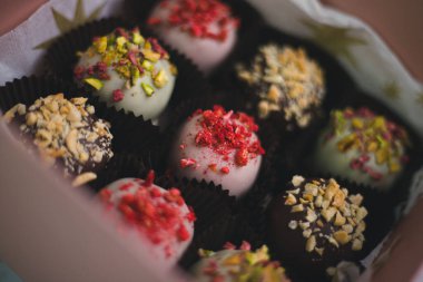 Çeşitli kekler, beyaz ve siyah çikolatalarla süslenmiş pastalar, hediye kutusunda fındıklar.