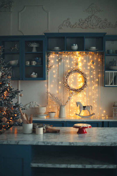 Christmas kitchen interior, with a Christmas tree, Christmas lights, kitchen in blue tones