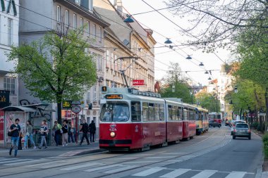 Vienna, AUSTRIA - 14 Nisan 2022. Tramvay Lohner Tipi E2 # 4324 ve Bombardier Tipi C5 # 1478 Viyana sokaklarında yolcularla yolculuk ediyor..