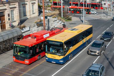 BRATISLAVA, SLOVAKIA - 25 Mart 2022. Irisbus otobüsü kavşağı 12.8 metre ve tramvay otobüsü Skoda 30TR # 6028 Bratislava sokaklarında ilerliyor..