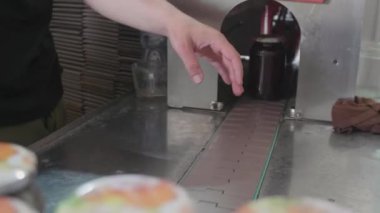 İşçiler özenle cam kavanozlara bal doldurur, canlı renkler gösterir ve verimli bir iş akışı sağlar..