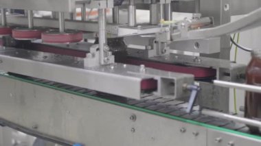 İşçiler süreci denetlerken otomatik makineler cam kavanozları bal ile dolduruyorlar..