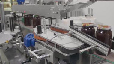 Altın bal kavanozları dikkatlice dolduruluyor ve bir fabrikada üretim hattına mühürleniyor..