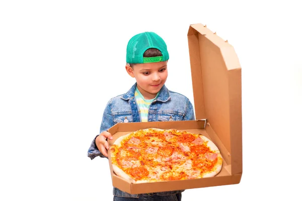 stock image A seven-year-old fashionable boy in a green cap and bright light green glasses holds an open box with a pizza isolated on the background.