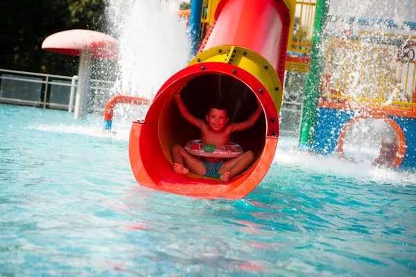 Cheerful Boy Rides Red Tube Slide Water Park — Stock Photo, Image