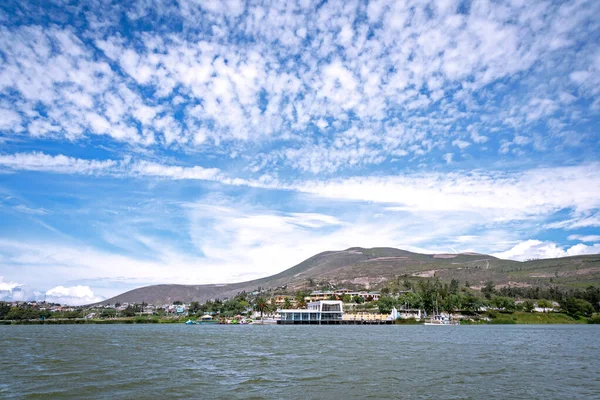 stock image View of the shore line and beautiful cloudy summer morning sky from the center of the Yahuarcocha lake, Imbabura Province, Ecuador. 