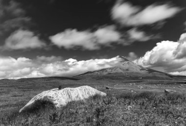 Cotopaxi volkanı, tarlalar ve çayırlar, kayalar ve hareket eden samanlar, hepsi Ekvador 'daki Cotopaxi Ulusal Parkı' ndaki muhteşem bir sahnenin parçası. Siyah ve Beyaz fotoğrafçılık. Hareket için kullanılan ND filtreleri.