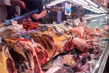 Madrid Local Market (Villa de Vallecas): A vibrant Spanish food hall showcasing diverse stalls with premium meats, poultry, fresh seasonal vegetables, olives, and regional delicacies.