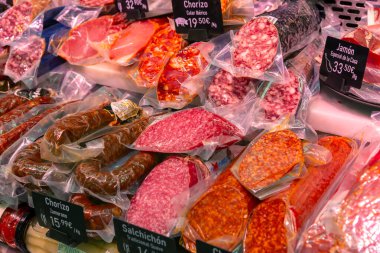 Madrid Local Market (Villa de Vallecas): A vibrant Spanish food hall showcasing diverse stalls with premium meats, poultry, fresh seasonal vegetables, olives, and regional delicacies.
