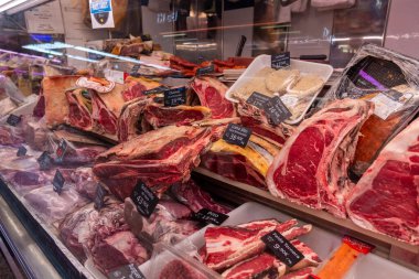 Madrid Local Market (Villa de Vallecas): A vibrant Spanish food hall showcasing diverse stalls with premium meats, poultry, fresh seasonal vegetables, olives, and regional delicacies.