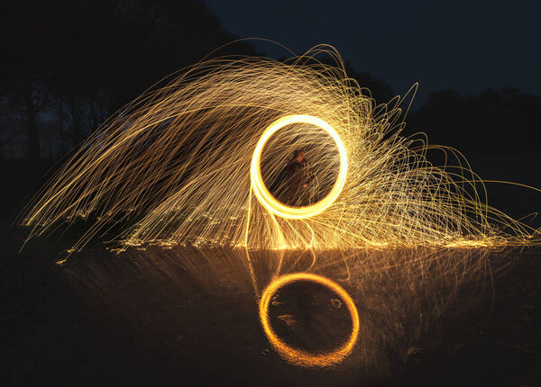 Turning steel wool on fire in the air above the water — Stock Image Turning Steel Wool Fire Air Water Royalty Free Stock Photos