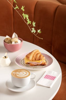 Kahvaltı masası, kruvasan ve kahve bir restoran masasında servis edilir.