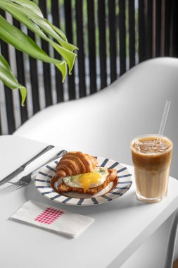 Kahvaltı masası, kruvasan ve kahve bir restoran masasında servis edilir.
