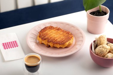 Kızarmış peynirli kruvasan tostu ve kahve..